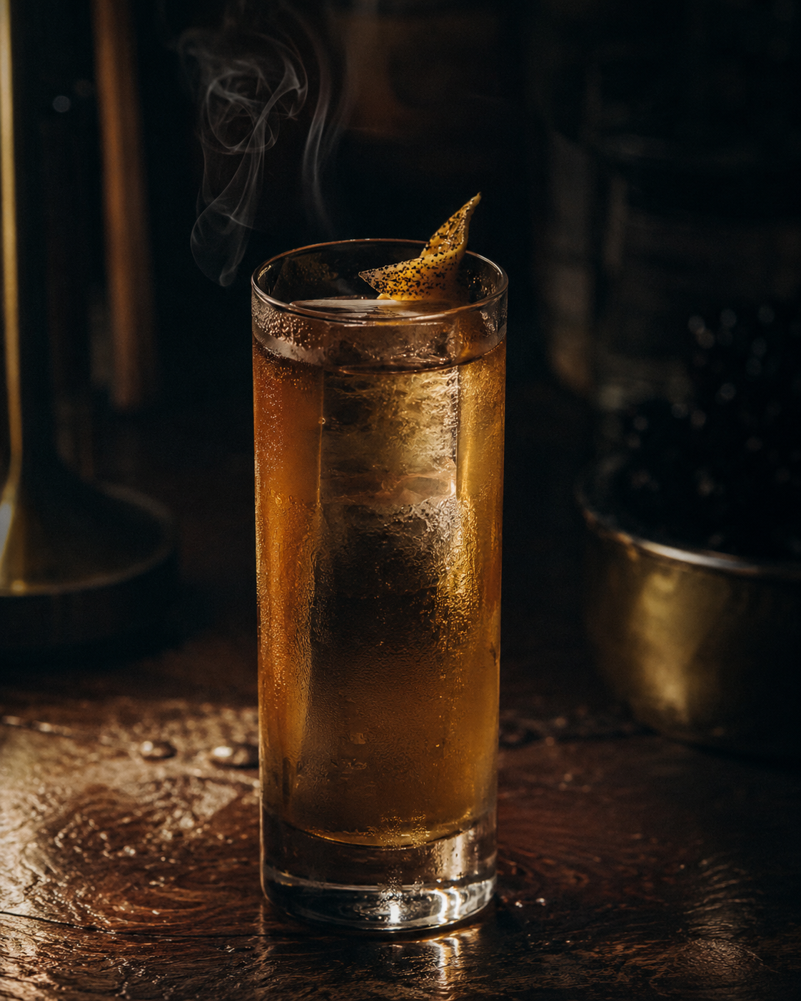 Tall highball with a single clear ice block, amber spirit catching the light.