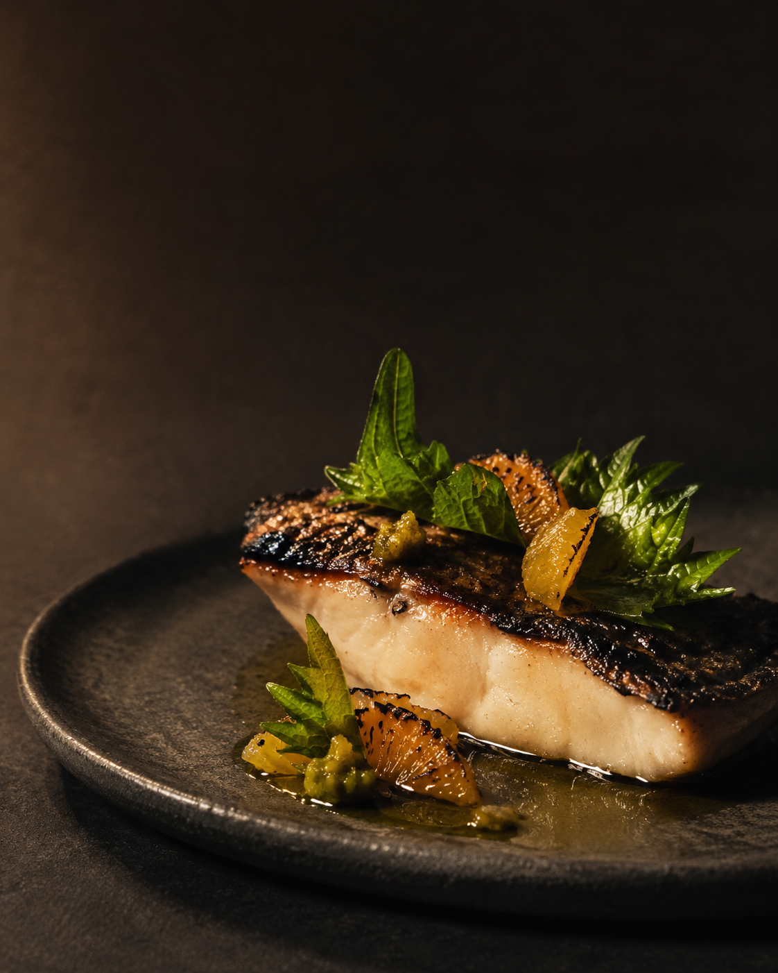 Charred kingfish at Ember House — cooked quickly over flame to keep the centre clean and delicate, dressed with yuzu kosho, burnt citrus and shiso, finished with smoked oil.